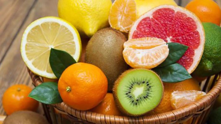 Un grupo de naranjas y un tazón de frutaDescripción generada automáticamente